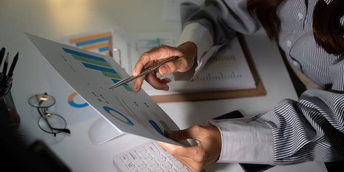 Late Night Work. Professional analyzing financial reports and charts at desk. photo