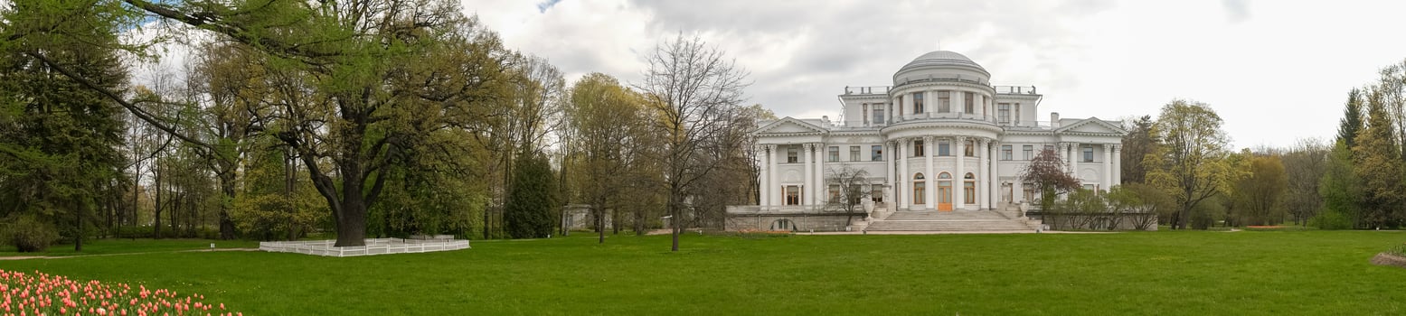 Celebrating Springtime in a Historic Mansions Garden With Blooming Tulips and Lush Greenery Under a Cloudy Sky photo