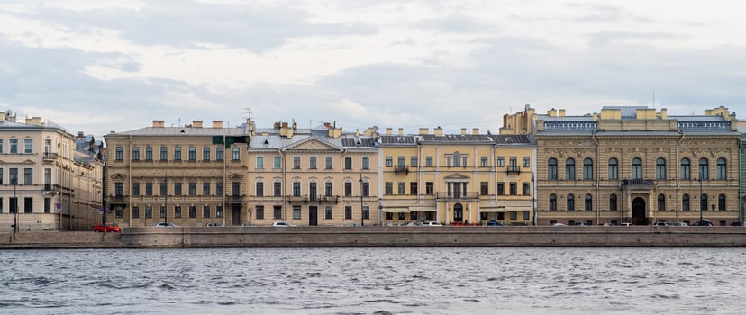 Historic Buildings Along the Neva River in St Petersburg Showcasing Classic Architecture and Urban Life During a Cloudy Day photo