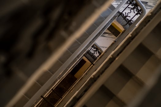 Staircase Interior View With Railings in a Retro Building Showcasing Geometric Lines and Shadows During Daytime photo