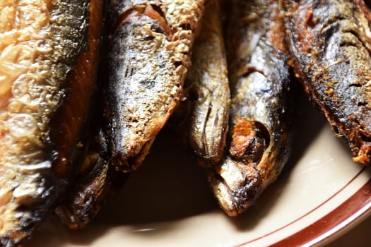 Plate of fried fish heads with cream background photo
