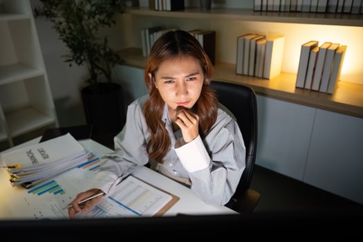 Late Night Concentration. A woman focused on her computer screen while working late. photo