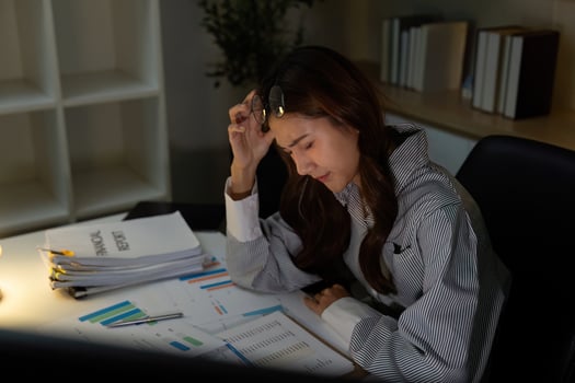 Late Night Stress. Professional woman feeling overwhelmed by financial analysis. photo