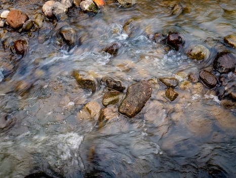 A small Stream of Water Flowing Over Rocks photo