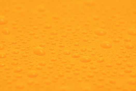 Yellow plastic background with many water drops. photo