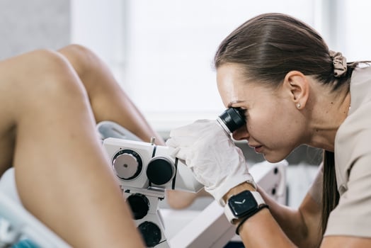 Gynecologist uses colposcope to examine cervix. Concept of women's health photo