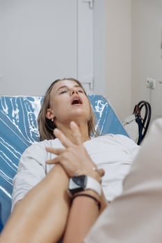In a delivery room, a young woman is pushing during labor, face tense. Concept of birth effort photo