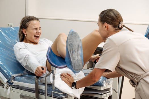 Young woman in labor and contractions in a delivery room on a gynecological chair. Concept of motherhood pain.. photo