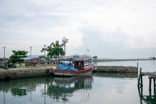 Fishing boat docked at scenic harbor coastal location maritime calm waters serene view photo