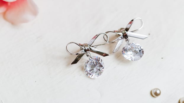 Elegant silver bow earrings with crystal accents fashion jewelry studio display close-up view glamour concept photo