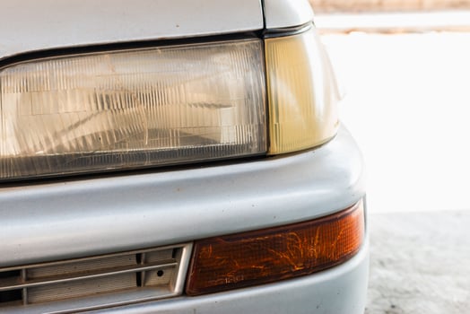Car headlight detail garage automotive indoor close-up vehicle maintenance photo