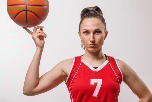 Confident Female Basketball Player in Red Jersey Posing with Ball for Sports Training and Competitions photo