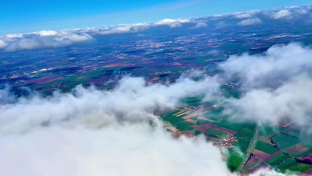 Stunning aerial footage brilliantly showcasing expansive green fields and fluffy clouds under a bright blue sky photo