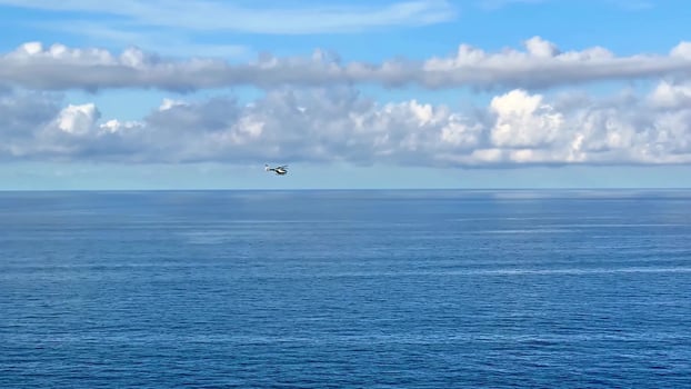 A small plane flying over the ocean photo