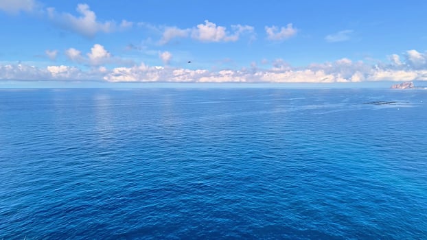 A breathtaking view of the calm ocean under a bright blue sky perfect for relaxation and inspiration. photo