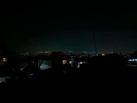 Night Cityscape Dark Silhouette of Buildings, Illuminated Horizon, Atmospheric Night Scene. photo