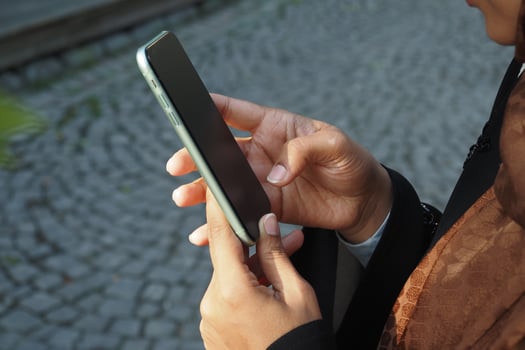 Person using smartphone outdoors in a city setting photo