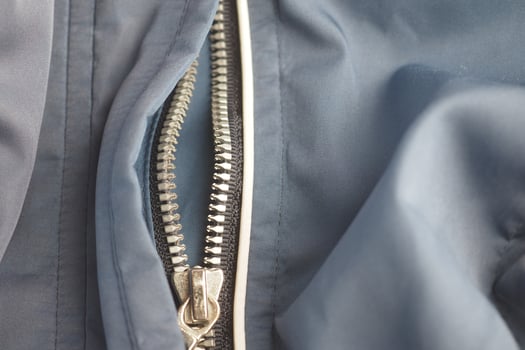 Close-up of a zipper on a blue fabric jacket photo