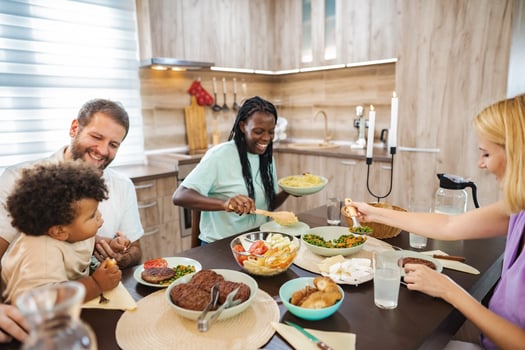 Family gathers for a lively meal in a cozy kitchen setting photo