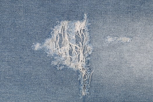 tear on blue jeans for pattern and background photo