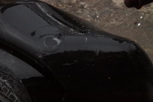 Close-Up of a Black Surface with a Circular Mark During Rain photo