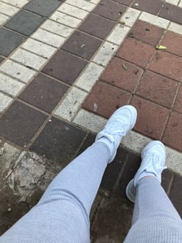 Top view of legs in white sneakers photo