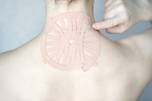 Female adult with therapeutic tape on neck for pain relief and muscle support. photo