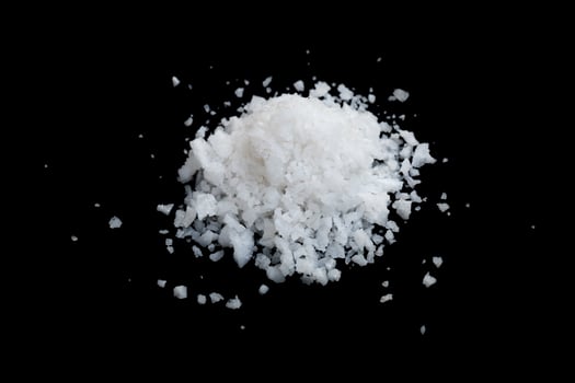 pile of white sea salt isolated on black photo