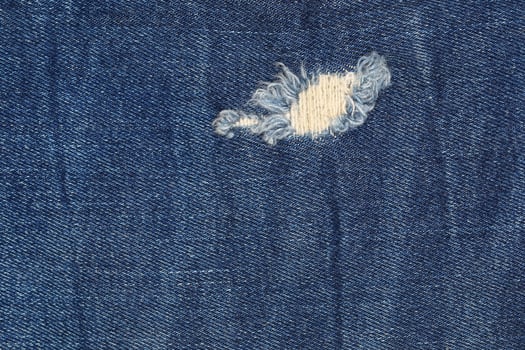 classic dark blue jeans texture with hole and tear photo