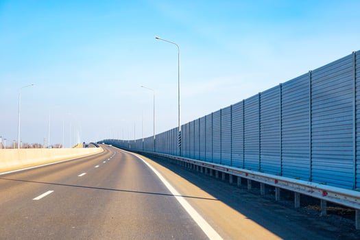 Anti-Noise screen along the road with moving transport. Noise protection fence preventing noise pollution photo