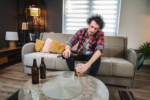 Young man pouring beer at home after work photo