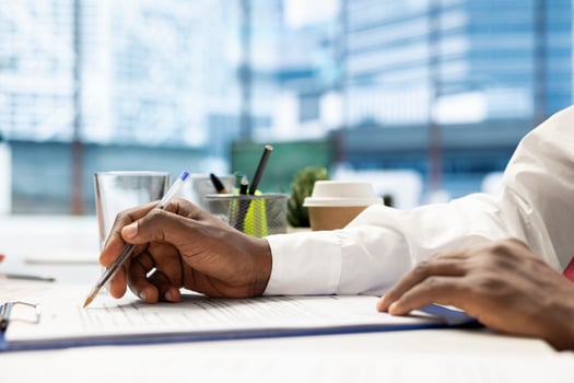 HR expert reading files, identifying right candidates for job opening, reviewing resumes to determine candidate qualifications. Close up of human resources worker doing screening photo