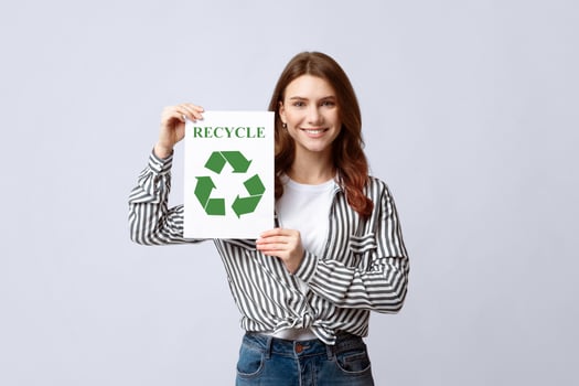 Recycle Concept. Young Smiling Woman Holding Placard With Green Recycling Sign, Positive Eco-Friendly Lady Volunteer Standing Over Light Grey Baclground In Studio, Copy Space photo