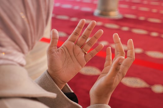 Hands raised in prayer during a serene moment in a mosque photo