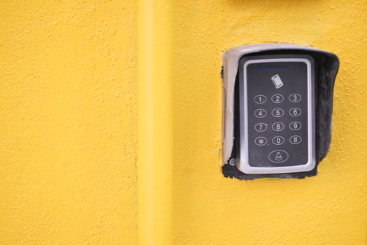 Keypad entry system on a bright yellow wall photo