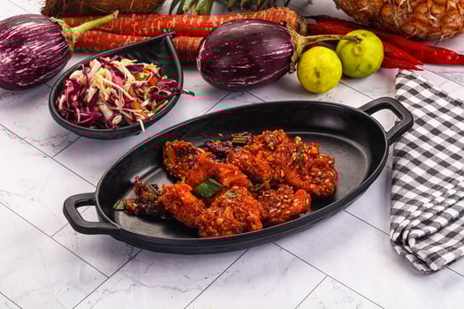 A bowl of food with vegetables and other food on a table photo