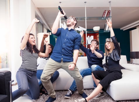 group of friends having fun at home singing a song together photo