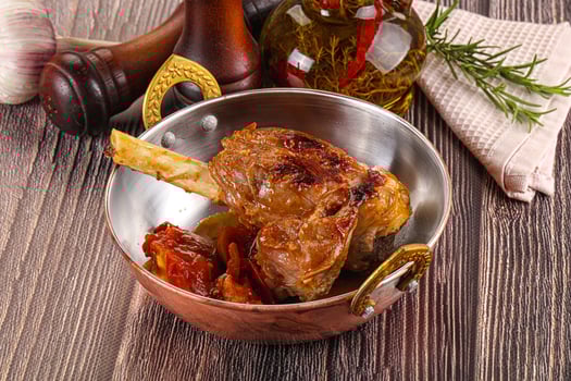 A wooden table with a silver bowl of food photo