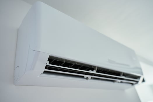 Modern air conditioner unit in white room. Home climate control photo