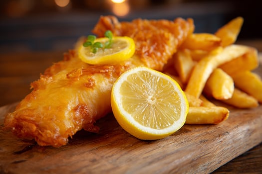 Realistic fish and chips served with lemon slice on white background close up image photo