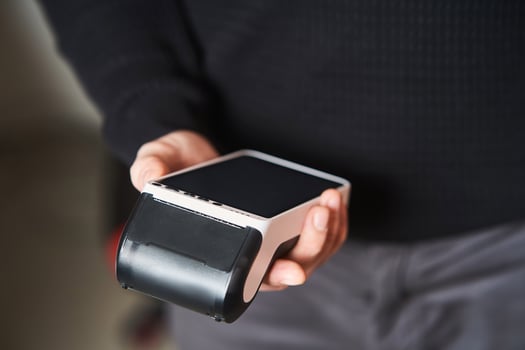 Bank terminal for contactless payment. Young man holds a terminal in his hands photo