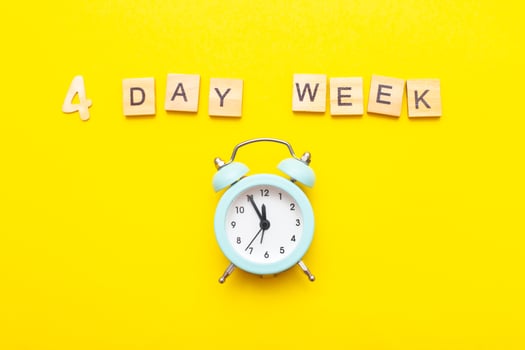 inscription four day week making by wooden cubes on yellow background photo