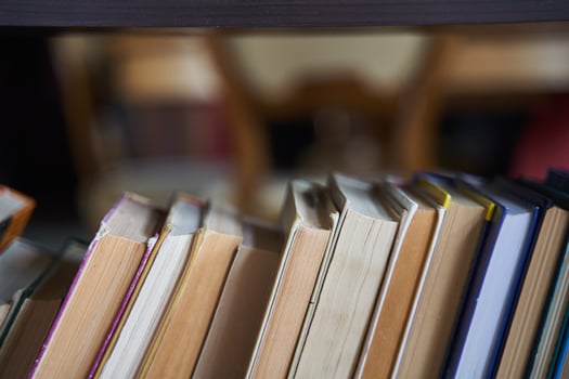 piles of books on a wooden bookshelf. photo