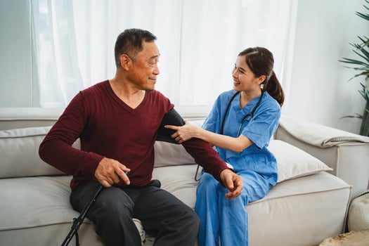 Nurse checks senior man's blood pressure photo