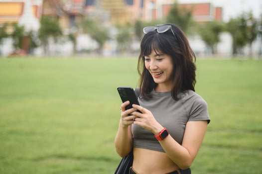 Joyful Southeast Asian woman teenager blogger and solo explorer. World travel guide concept with smartphone map to explore Bangkok Thailand for local cultural tourism experience in Asia photo