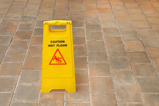 one yellow plastic wet floor sign on tile floor photo