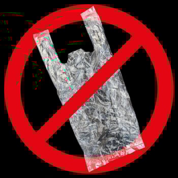 one clear plastic bag with red forbidden sign isolated on black photo