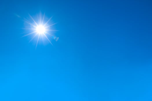 bright sun shines on clear blue sky. photo