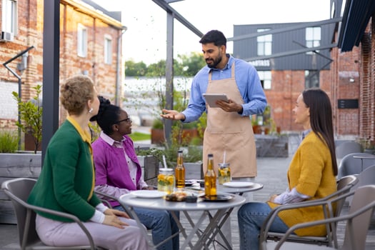 Waiter serving drinks to customers photo