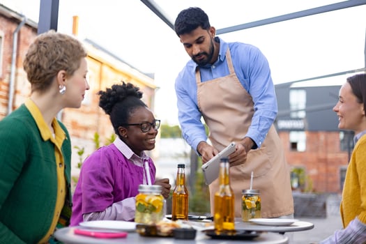 waiter serving drinks to friends outside photo